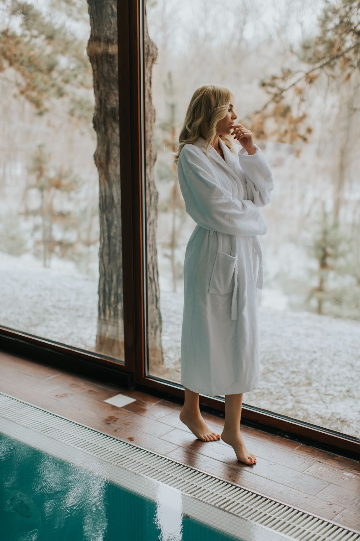 pretty-woman-in-bathrobe-standing-by-the-pool-in-2022-04-06-04-47-40-utc